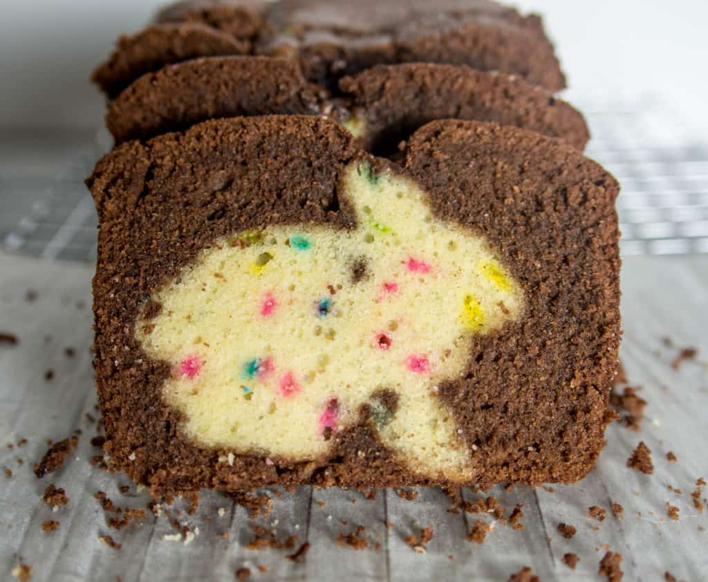 slices of chocolate funfetti hidden bunny cake sitting on a wire rack