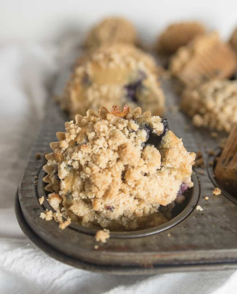 brown butter blueberry crumb muffins in the muffin tin after they're baked