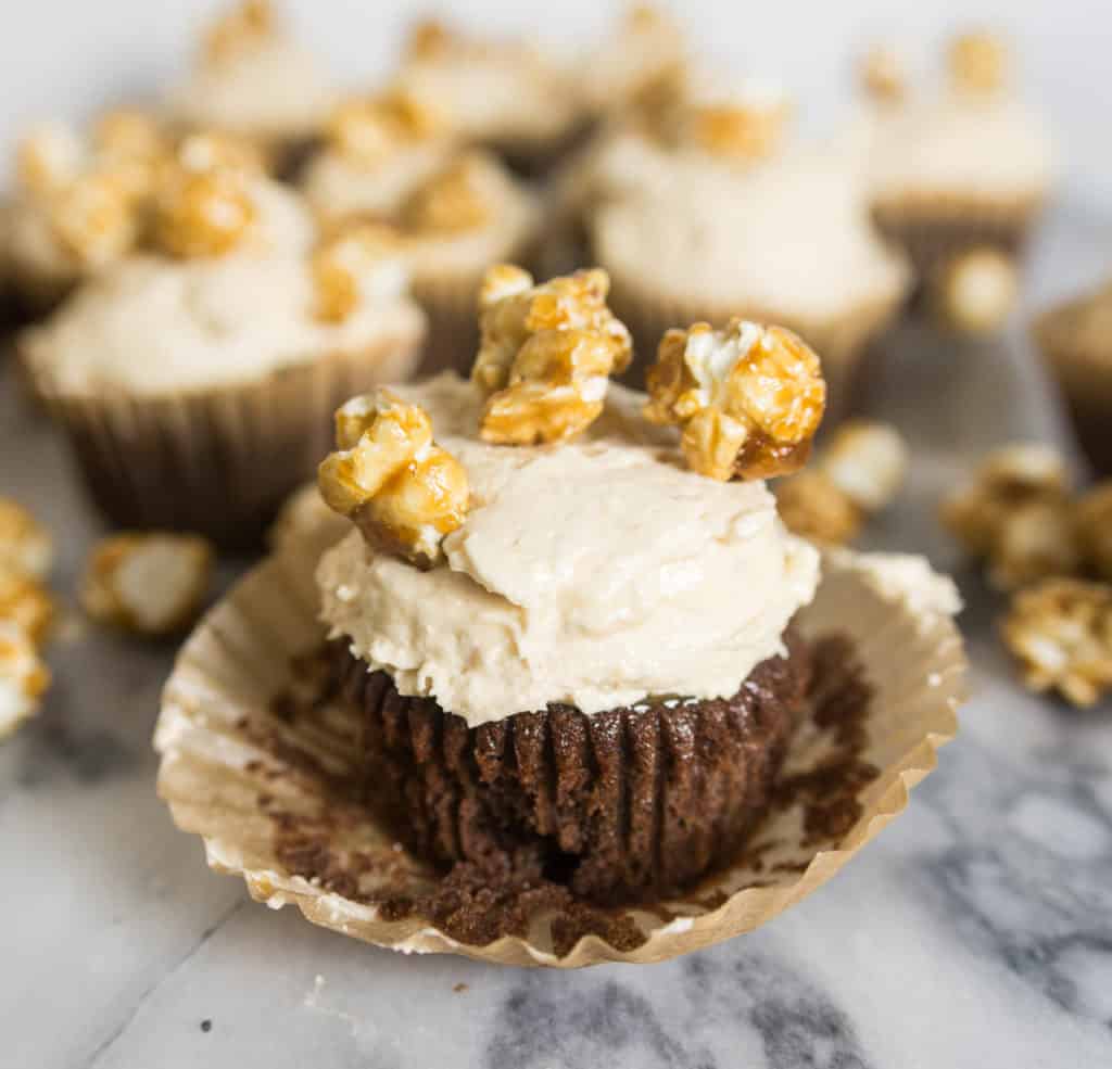 photo of a frosted cupcake with more chocolate caramel corn cupcakes in the background