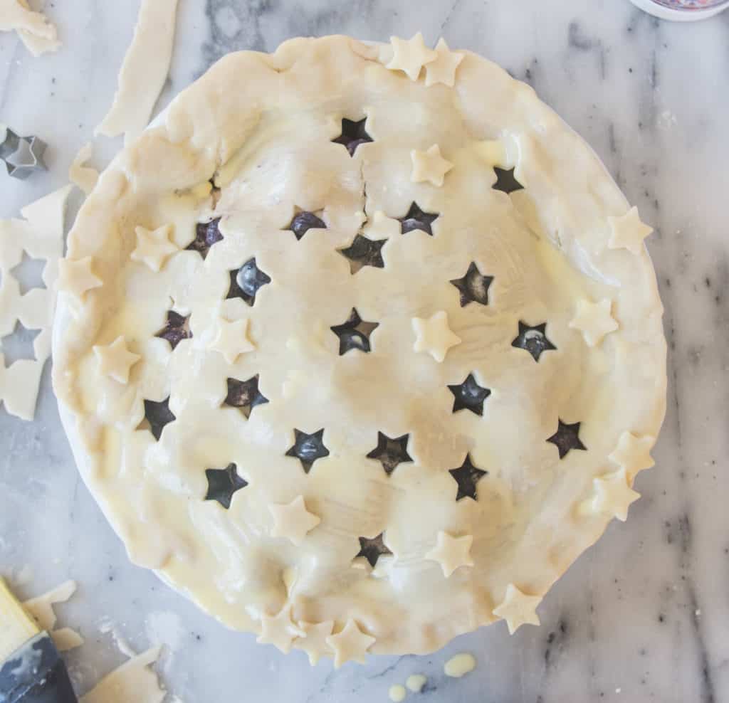 overhead shot of the unbaked blueberry pie with stars cut out of the crust