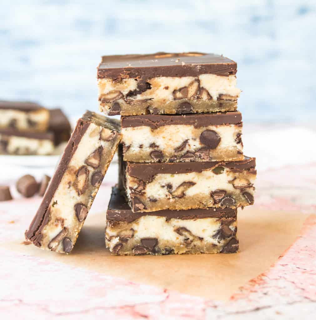 stack of peanut butter cup cheesecake bars with more bars in the background