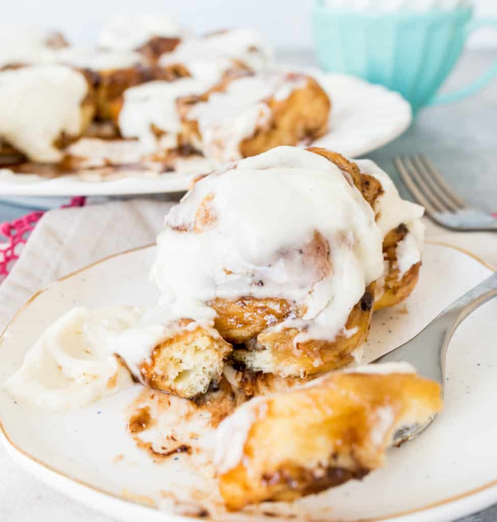overnight salted chocolate cinnamon rolls on a plate with a fork taking a bite out of one