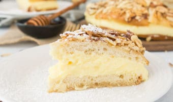 A recipe for bee sting cake--a delicious German dessert made with a yeasted cake topped with honey and almonds and filled with sweet pastry cream; it's the perfect dessert for your #Oktoberfest festivities!  #Oktoberfestbash #Oktoberfestrecipe