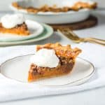slice of sweet potato pecan pie on a plate with more pie in the background
