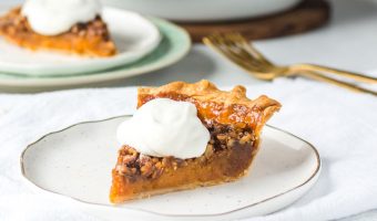 slice of sweet potato pecan pie on a plate with more pie in the background