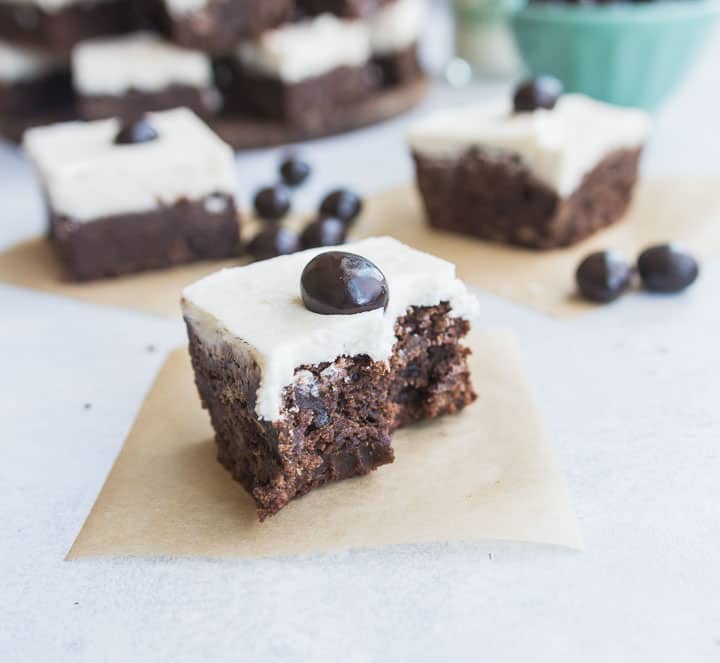 Irish cream espresso bean brownie with a bite taken out of it, sitting on a square of parchment paper