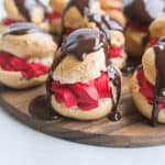 close-up photo of red velvet profiteroles with chocolate glaze dripping down