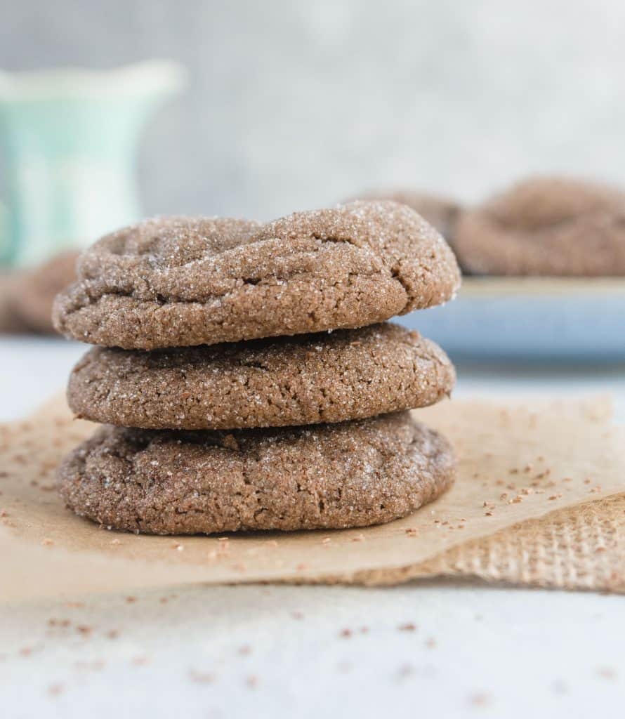 stack of three cookies sitting in a piece of parchment paper with a piece of burlap underneath