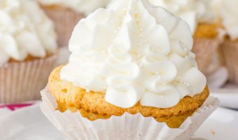 cupcake sitting on a plate with more white chocolate cupcakes in the background