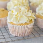 lemon curd cupcakes on a wire baking rack and topped with frosting