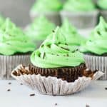 chocolate mint cupcake with the wrapper peeled off and more cupcakes in the background
