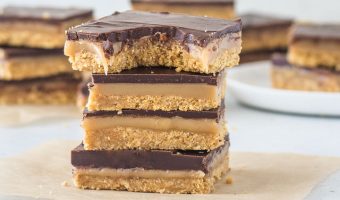 stack of chocolate caramel bars, one of which has a bite taken out of it