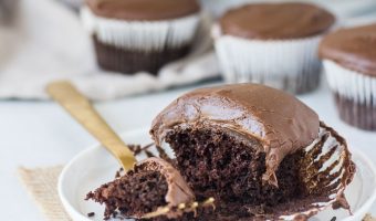cupcake on a plate with a fork taking a bite out of it and more easy chocolate cupcakes in the background