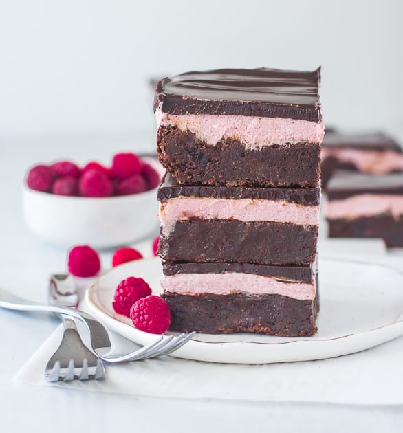 stack of raspberry brownies on a plate with two forks next to it