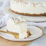 slice of eggnog cheesecake on a plate with a fork taking a bite out of it
