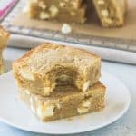 two white chocolate blondies stacked on a plate
