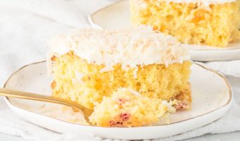 slice of fruit cocktail cake on a plate with a fork taking a bite out of it
