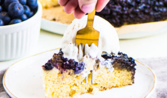 slice of upside-down cake on a plate with a fork taking a bite out of it