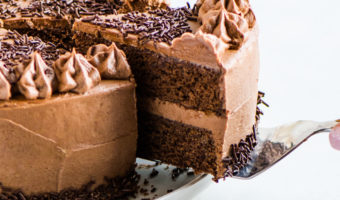 cake on a cake plate with a cake server lifting a slice up