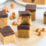 two squares of fudge stacked, with a bite taken out of the top square and more fudge around it