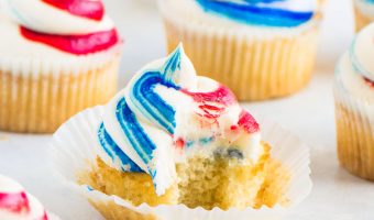 fourth of July cupcake with a bite taken out of it and more cupcakes surrounding it