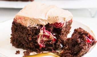 slice of cake on a plate with a fork taking a bite out of it and more cake slices behind it